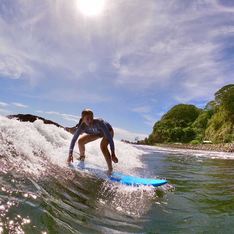 Jeune surfeuse dans les vagues durant un stage vacances
