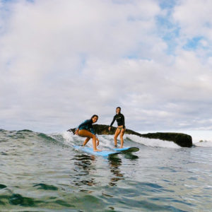 Deux surfeuses sur les vagues de Tahiti