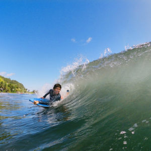 Enfant en bodyboard dans les vagues à Tahiti
