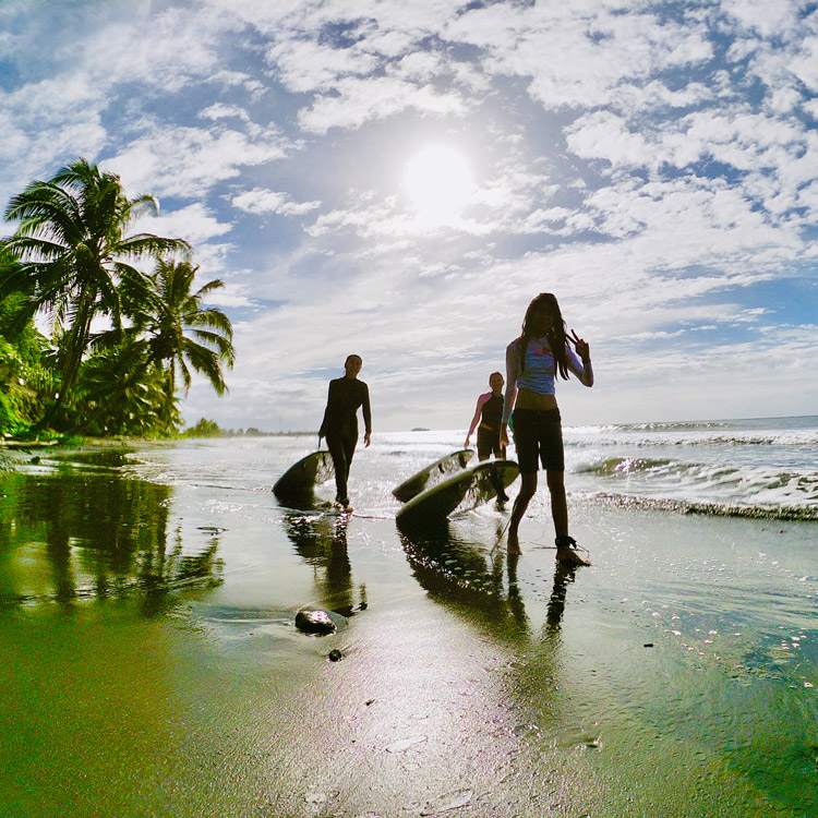 Surfeuses sur une plage de Tahiti après une leçon de surf
