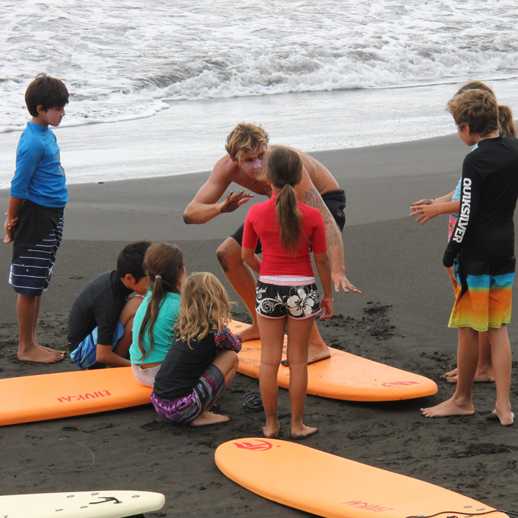 briefing surf sur la plage avec moniteur de surf et élèves